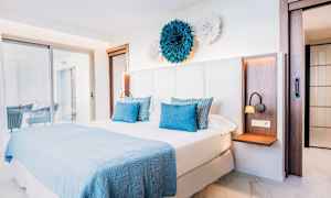 Soveværelse med en dobbeltseng og lys, moderne indretning. (AI-genereret tekst)