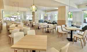 En moderne og lys indendørsrestaurant med træmøbler og dekorative lamper. (AI-genereret tekst)