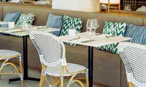 Restaurant med bordopsætning og puder. (AI-genereret tekst)