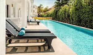 Soldæk med liggestole ved en pool. (AI-genereret tekst)