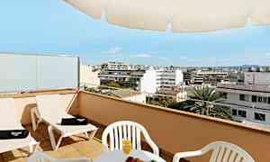 En terrasse med stole, et bord med frugt og juice samt udsigt over en by. (AI-genereret tekst)