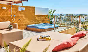 Terrasse med spabad, siddepladser og åben bruser med udsigt over omgivelserne. (AI-genereret tekst)