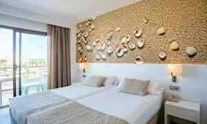 Hotelværelse med to enkeltsenge, dekorativt billede med skaller og balkon med udsigt. (AI-genereret tekst)