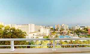 Hotel og poolområde set fra en altan. (AI-genereret tekst)