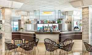 Hotelbar med stole og borde i forgrunden. (AI-genereret tekst)