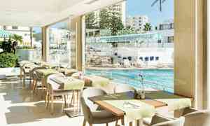 En restaurant med udsigt over en pool og liggestole. (AI-genereret tekst)