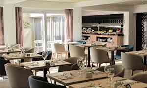 Billedet viser en moderne restaurant med borde og stole samt en buffet med mad. (AI-genereret tekst)