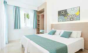 Et lyst og moderne hotelværelse med en dobbeltseng og åbne hylder. (AI-genereret tekst)