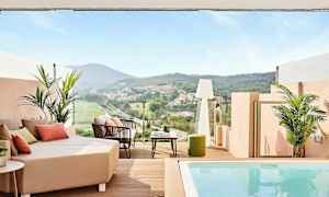 En terrasse med udsigt over en grøn dal og huse i det fjerne, med siddepladser og en lille pool. (AI-genereret tekst)