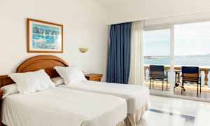 Hotelværelse med to enkeltsenge og altan med havudsigt. (AI-genereret tekst)