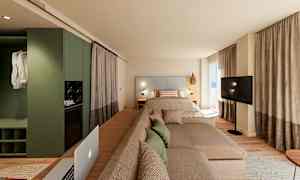 Moderne hotelværelse med seng, sofa og tv foran store vinduer. (AI-genereret tekst)