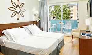 Billede af et lyst hotelværelse med to enkeltsenge, en dekorativ vægdekoration, en balkon med havemøbler samt lyse gardiner. (AI-genereret tekst)