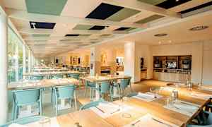 Indendørs miljø af en restaurant med dækkede borde og lys indretning. (AI-genereret tekst)