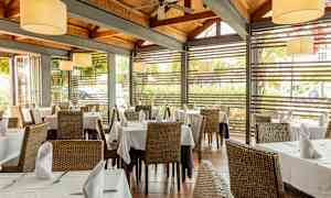 Restaurant med dækkede borde og store vinduer. (AI-genereret tekst)