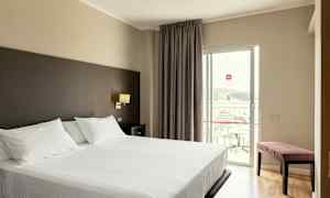 Hotelværelse med en dobbeltseng og altan. (AI-genereret tekst)