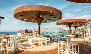 Udendørs serveringsområde med moderne skærme og udsigt over havet. (AI-genereret tekst)