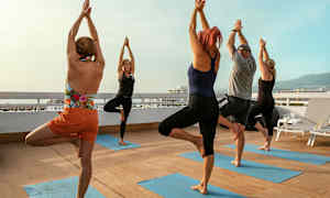 En gruppe mennesker laver yogaøvelser på en terrasse. (AI-genereret tekst)