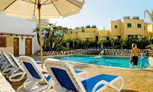 Billede med en udendørs pool omgivet af liggestole og planter. (AI-genereret tekst)