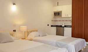 To enkeltsenge i et værelse med køkkenområde. (AI-genereret tekst)