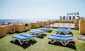 Tagterrasse med liggestole og udsigt over havet. (AI-genereret tekst)