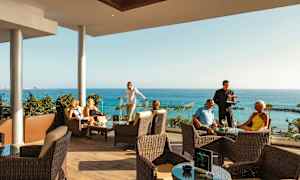 Personer, der sidder på en terrasse med havudsigt. (AI-genereret tekst)