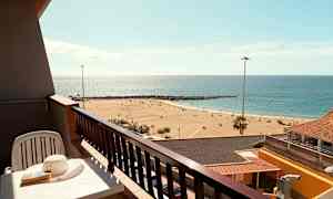 En balkon med udsigt over en sandstrand og havet. (AI-genereret tekst)