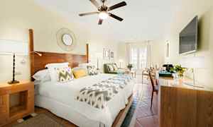 Et lyst hotelværelse med dobbeltseng, trædetaljer og moderne indretning. (AI-genereret tekst)