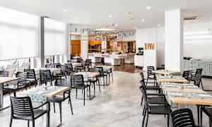 En spisesal med borde og stole samt dekorationer i loftet. (AI-genereret tekst)