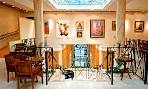 Interiør af en elegant bygning med kunstværker på væggene og siddepladser omkring. (AI-genereret tekst)