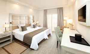 Et hotelværelse med en dobbeltseng, skrivebord og stol. (AI-genereret tekst)