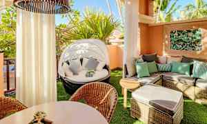 En møbleret balkon med liggestole, bord og planteudsmykning. (AI-genereret tekst)