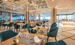 En restaurant med dækkede borde og stole. (AI-genereret tekst)