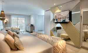 Moderne hotelværelse med dobbeltseng, siddeområde og tv. (AI-genereret tekst)