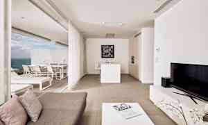 En moderne lejlighed med åben planløsning, lys indretning og udsigt over havet. (AI-genereret tekst)