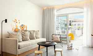 Moderne stue med sofabord, sofa og udsigt til en terrasse. (AI-genereret tekst)