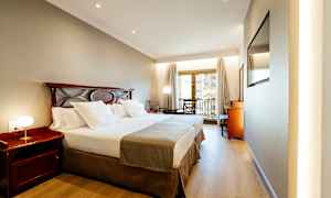 Hotelværelse med dobbeltseng og altan. (AI-genereret tekst)