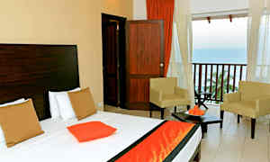 Billede af et hotelværelse med en seng, to stole og en balkon med udsigt over havet. (AI-genereret tekst)