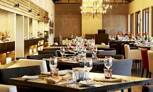 En elegant restaurant med dækkede borde og en lysekrone. (AI-genereret tekst)