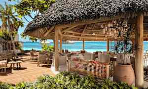 En åben restaurant med stråtag tæt på stranden. (AI-genereret tekst)