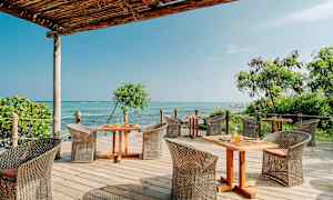 En terrasse med havemøbler og udsigt over havet. (AI-genereret tekst)