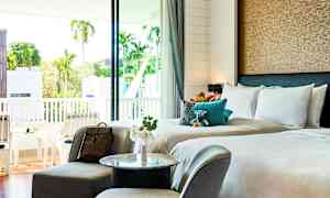 Hotelværelse med dobbeltseng, siddeområde og balkon med udsigt. (AI-genereret tekst)