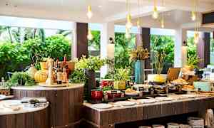 Buffetbord med forskellige madmuligheder og dekorationer, placeret i et åbent og lyst miljø. (AI-genereret tekst)