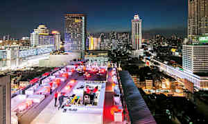 En tagterrassebar med aftenbelysning og en baggrund af høje bybygninger. (AI-genereret tekst)