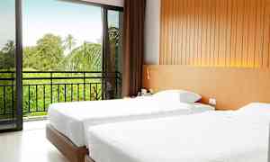 Et hotelværelse med to enkeltsenge, en skydedør fører til en altan med udsigt over grønne områder. (AI-genereret tekst)