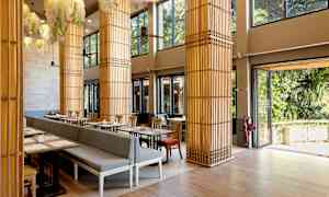 Et lyst restaurantområde med store vinduer og dekorative søjler. (AI-genereret tekst)