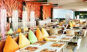 En moderne restaurant med hvide borde, farverige puder og dekorationer. (AI-genereret tekst)