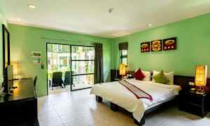 Et hotelværelse med dobbeltseng og grønne vægge samt en balkon med udsigt til grønne områder. (AI-genereret tekst)