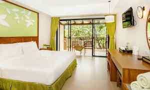 Et hotelværelse med en dobbeltseng, skrivebord og udsigt til en balkon. (AI-genereret tekst)