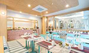 Et lyst og moderne morgenmadsområde med borde, blå stole og buffetområde. (AI-genereret tekst)