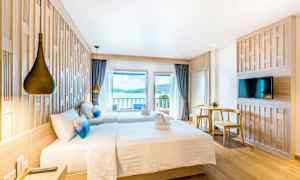 Hotelværelse med to senge, udsigt over havet og moderne indretning. (AI-genereret tekst)